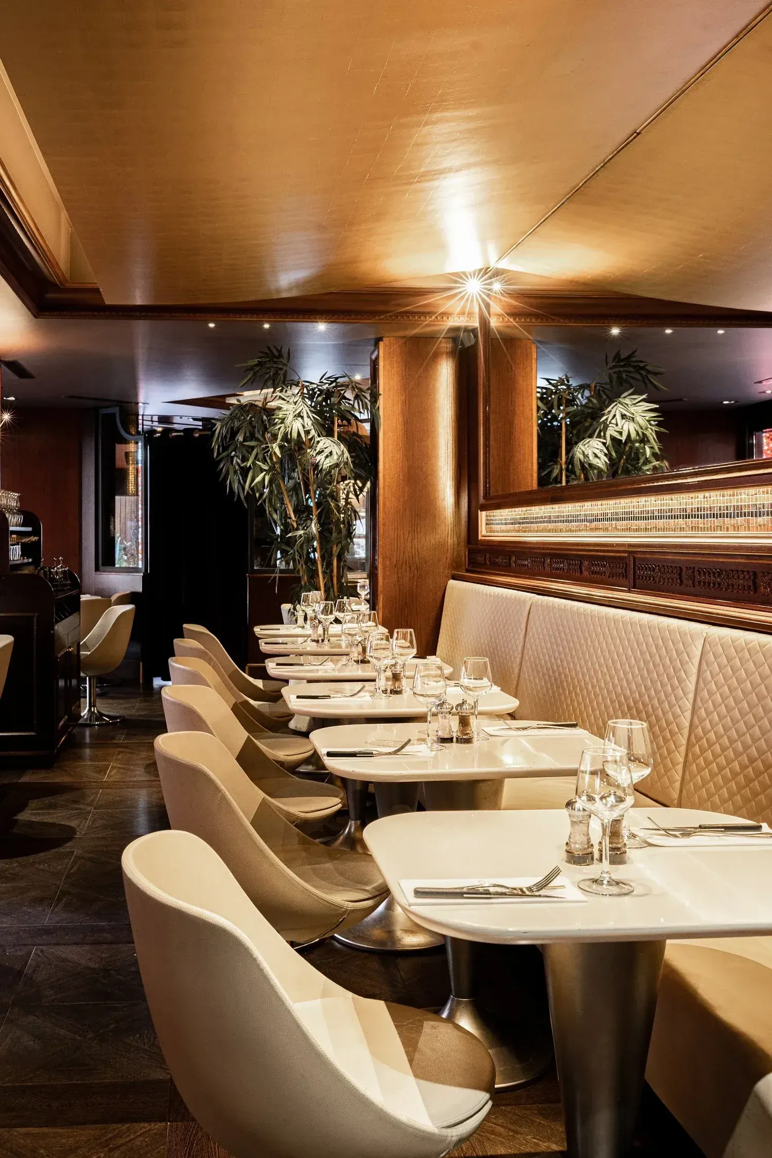 A row of set tables running along the banquette in the main dining room