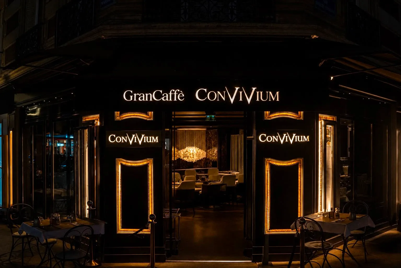 The illuminated GranCaffè Convivium façade and entrance on Rue Marbeuf at night