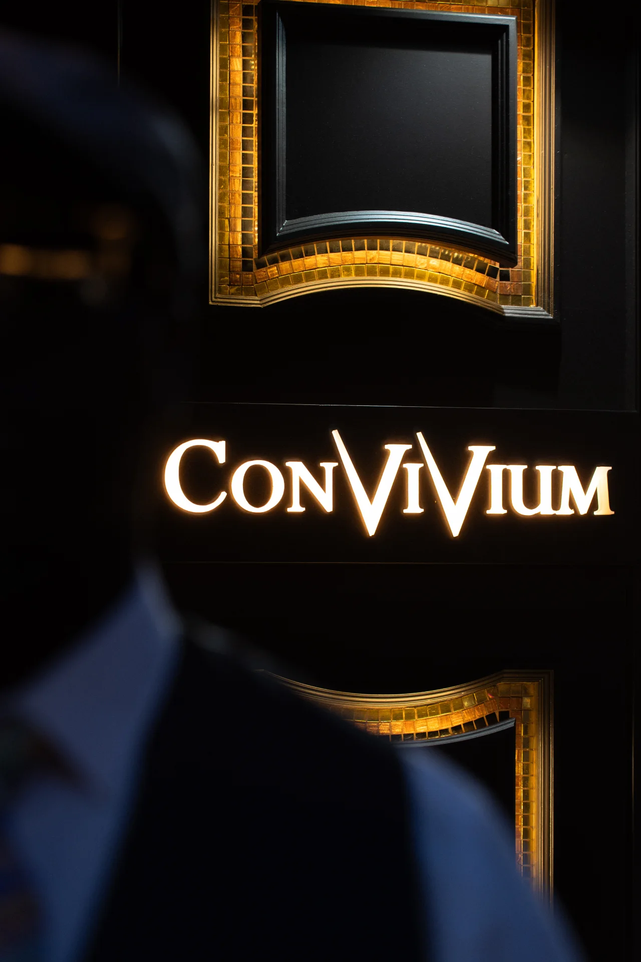Enseigne lumineuse Convivium à l'entrée du restaurant