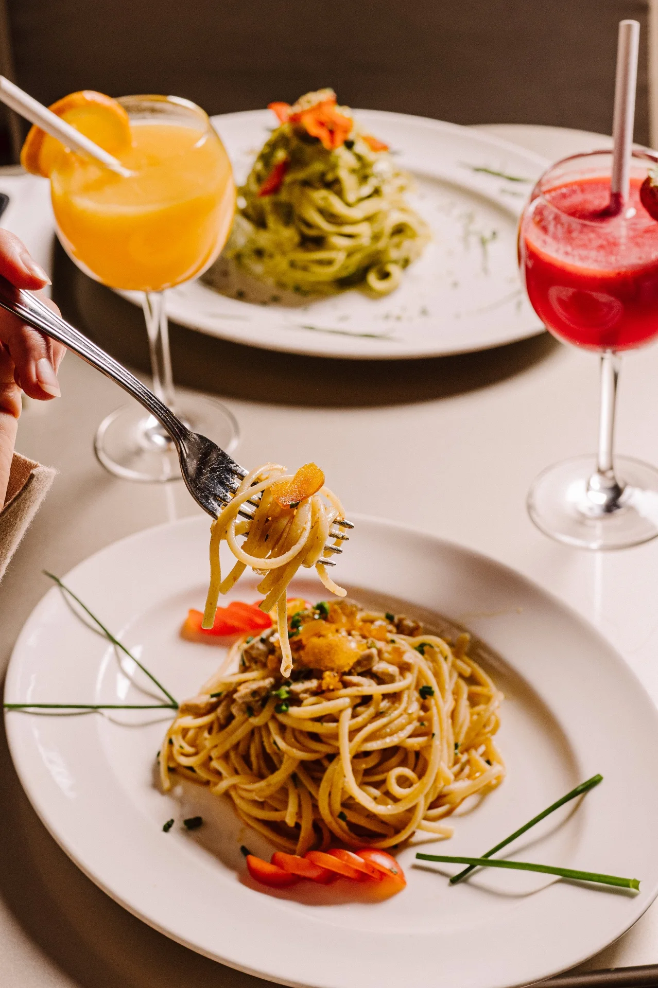 Linguine servies à table avec tagliatelle au pesto et jus frais