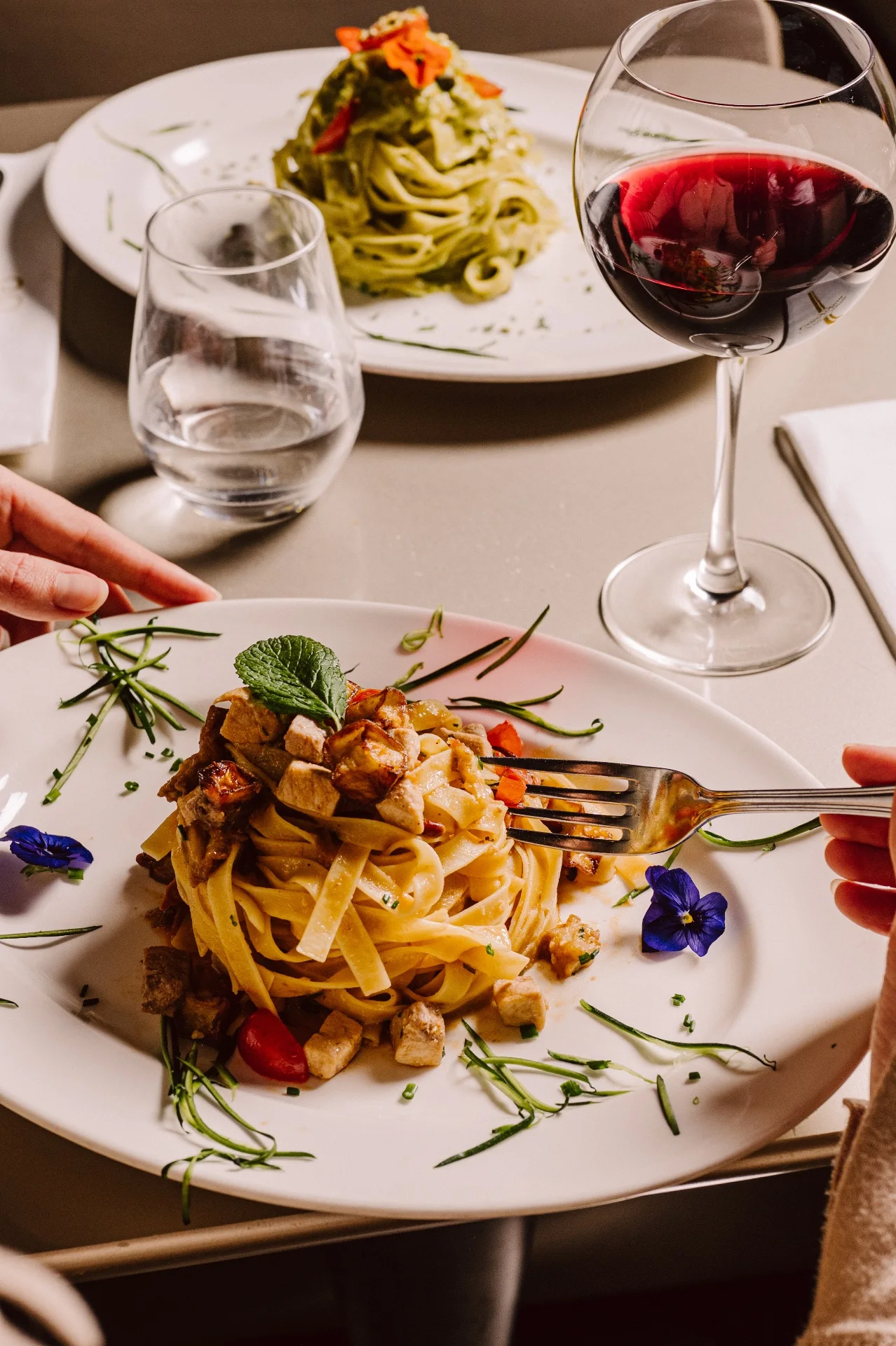 Tagliatelle servies à table avec un verre de vin rouge