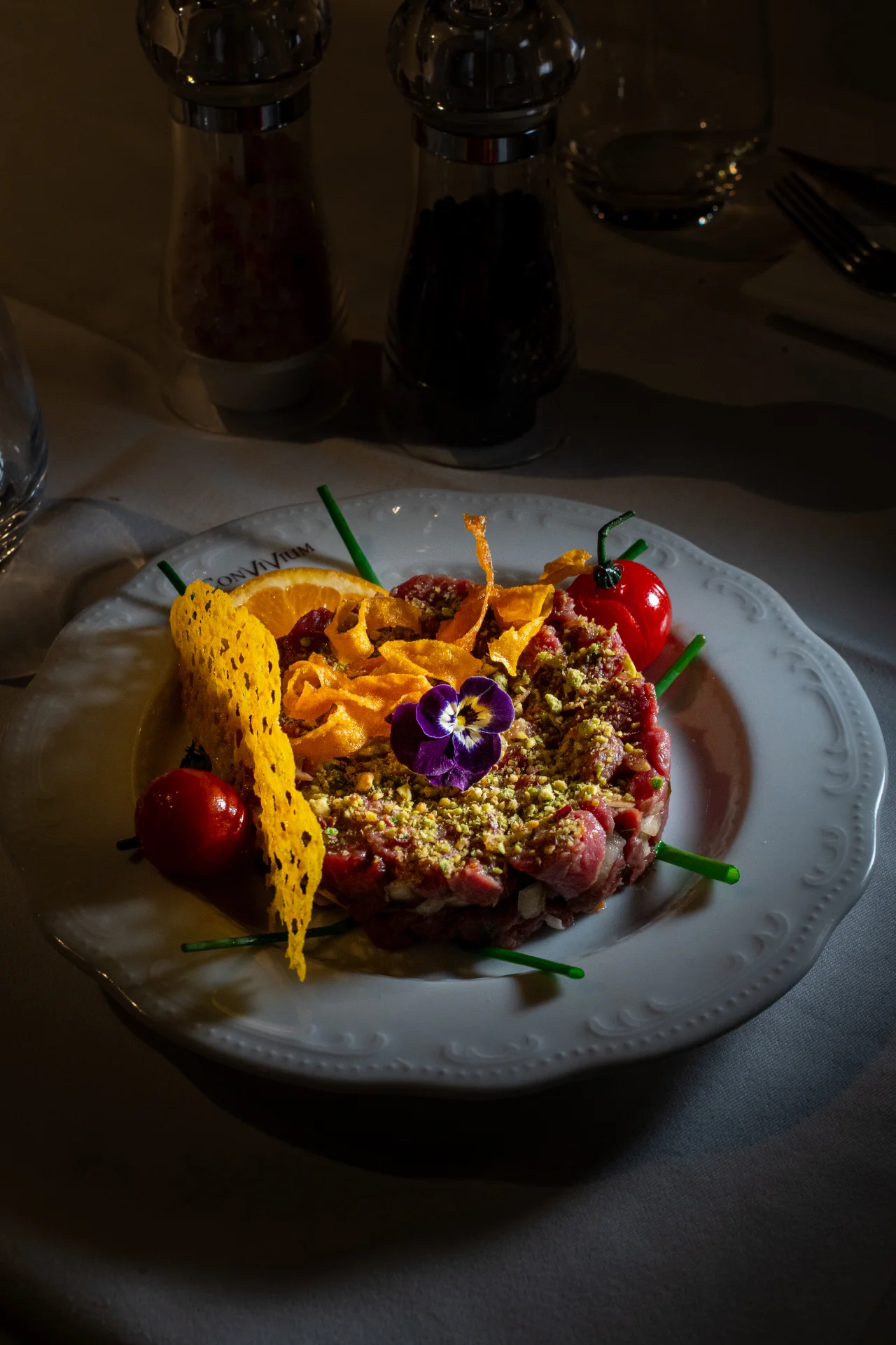 Tartare de bœuf aux pistaches, tuile de parmesan et fleur